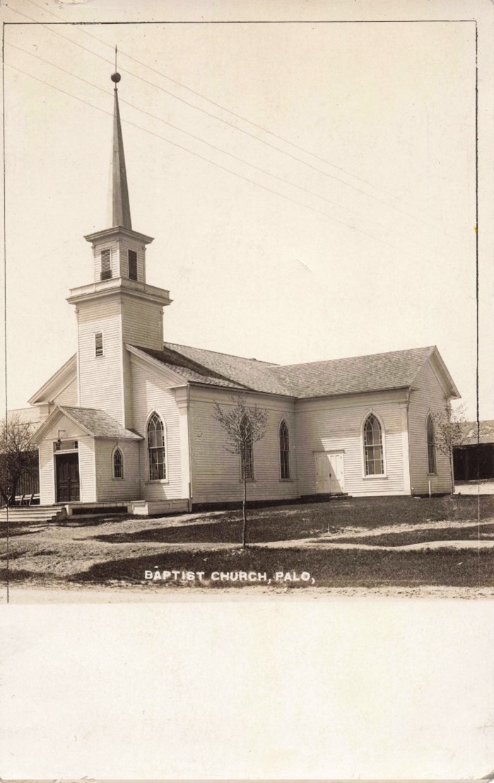 Front of a postcard showcasing a church; the church has nine windows and a steeple. Along the bottom, in handwritten, it reads: Baptist Church.