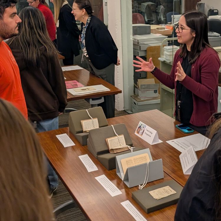 instruction4 Emi Hastings teaching students while standing behind many books from the Clements collections.