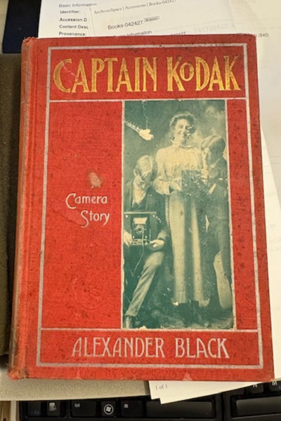 Captain Kodack Cover of "Captain Kodak: Camera Story" by Alexander Black. Red cover with a shot of three people taken in a mirror to show the camera.