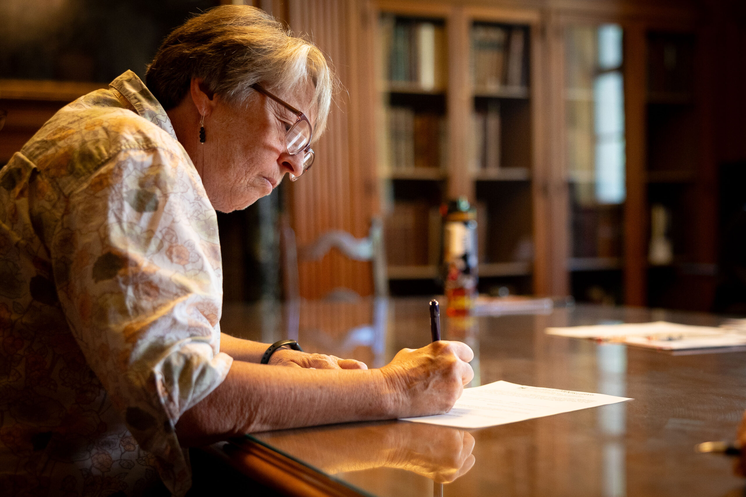 Shannon Hirth signing paperwork to donate materials to the Clements.
