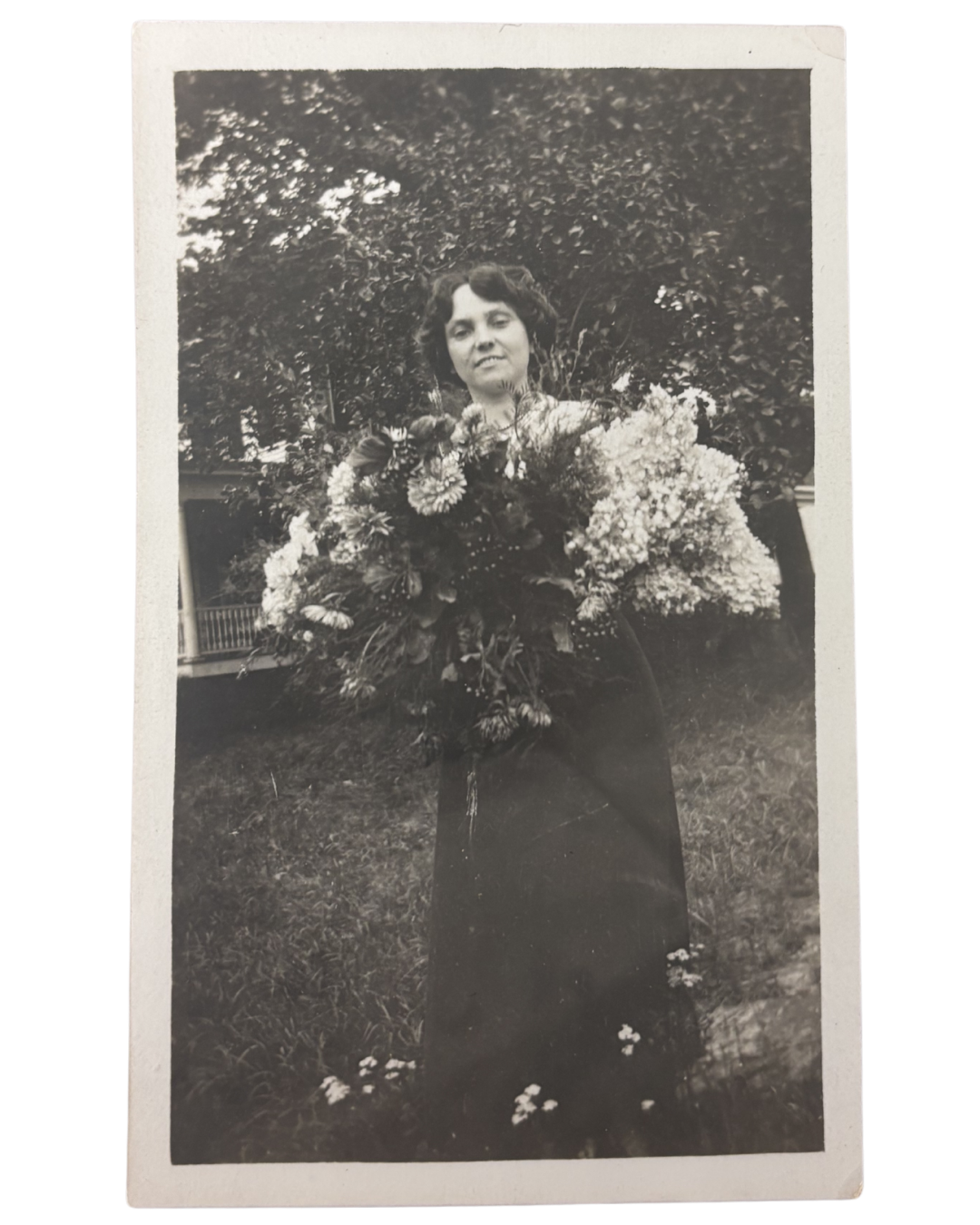Florence holding flowers. Photograph of Florence Smith Romaine holding an armful of flowers.