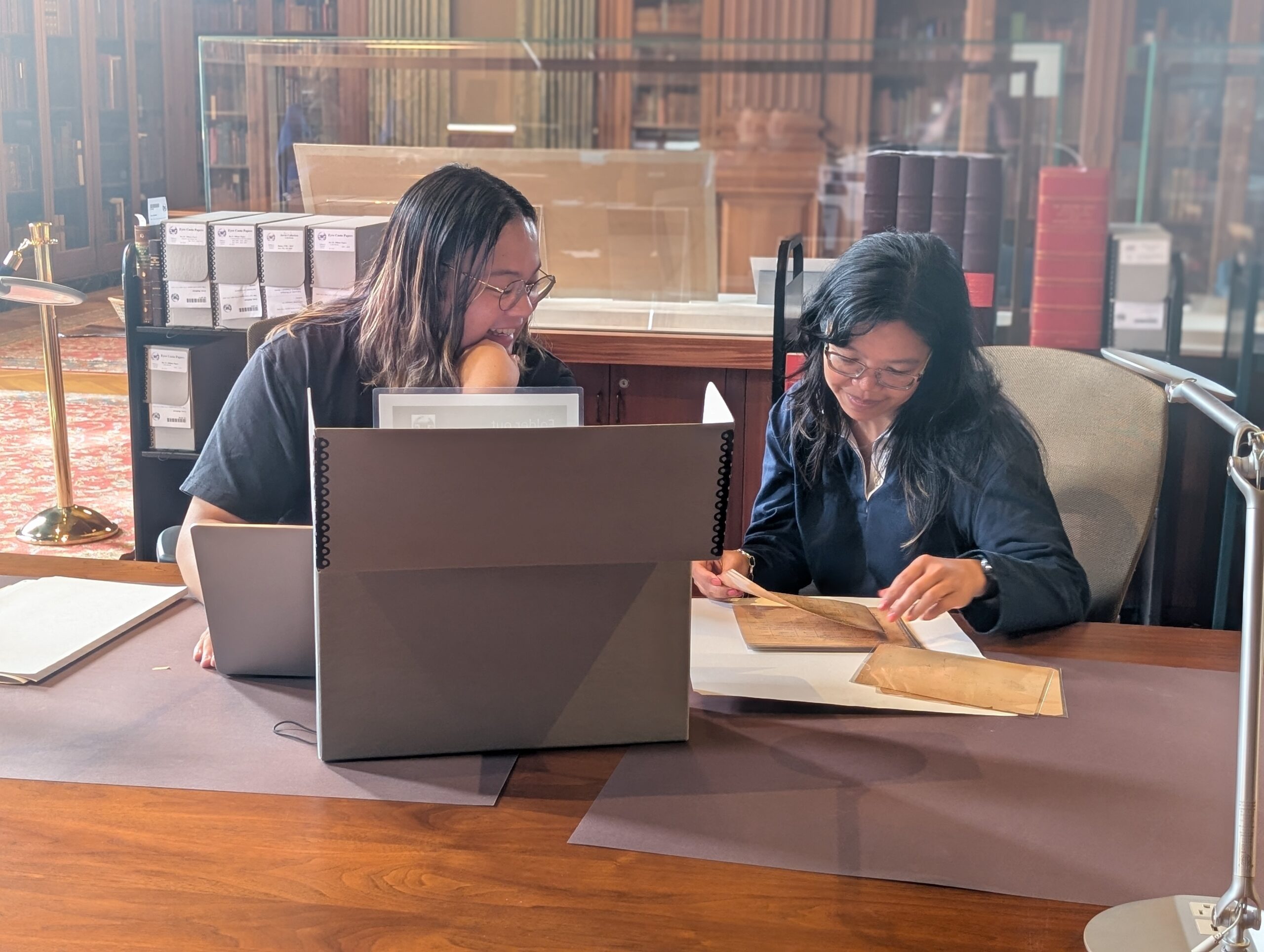 1000057159 Two research fellows discussing a manuscript in the Avenir Foundation Reading Room of the Clements Library.