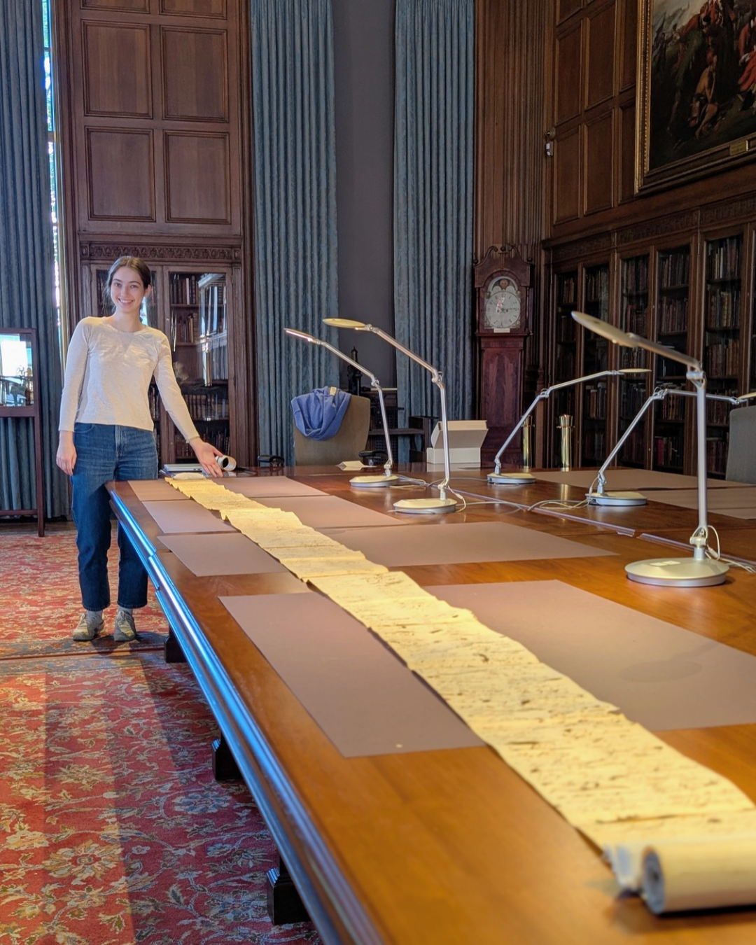 Ava with scroll Ava Wilcox posing with a manuscript scroll taking up the length of multiple combined tables.